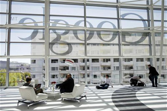 Attendees sits in front of a Google logo during Google I/O Conference at Moscone Center in San Francisco