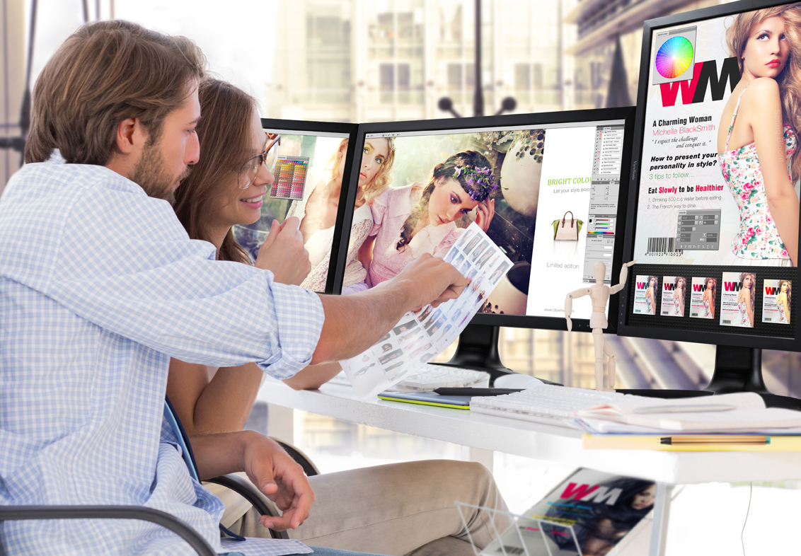 Photo editors viewing contact sheet sitting at desk in office