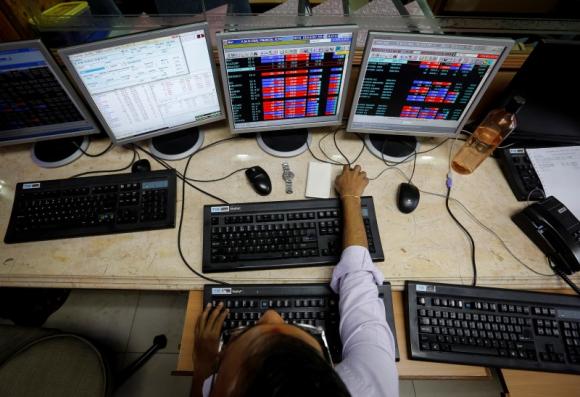A broker monitors share prices while trading at a brokerage firm in Mumbai