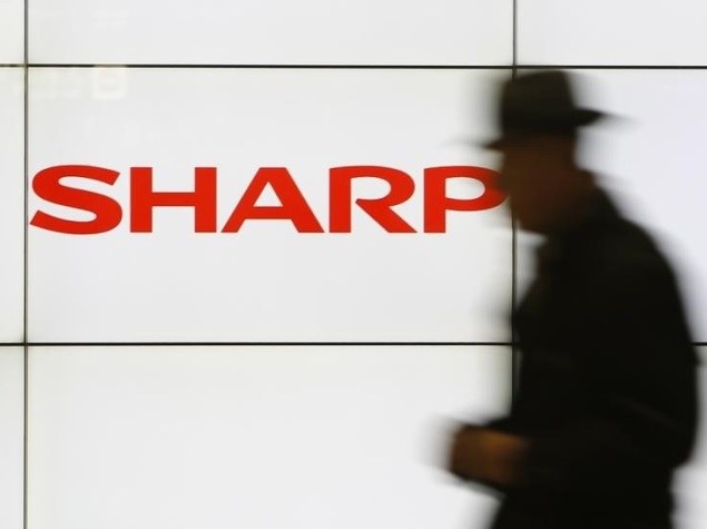 man walking past sharp logo