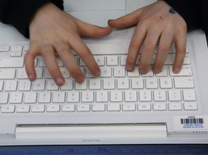 man typing on mac book